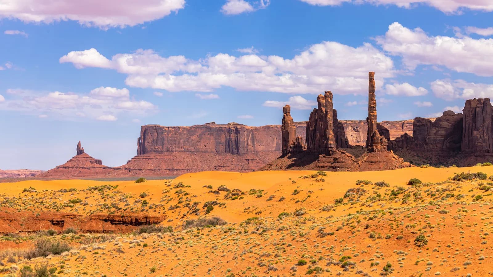 Scenic view of monument valley desert landscape with sandstone buttes and mesas under blue sky