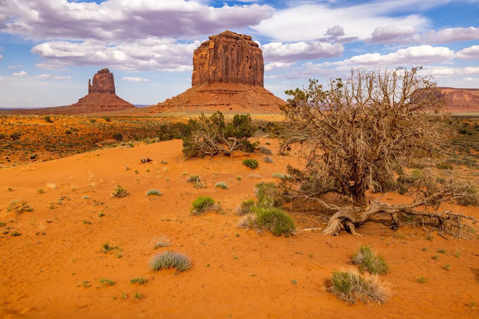 Scenic view of monument valley buttes in arizona desert landscape under a cloudy blue sky