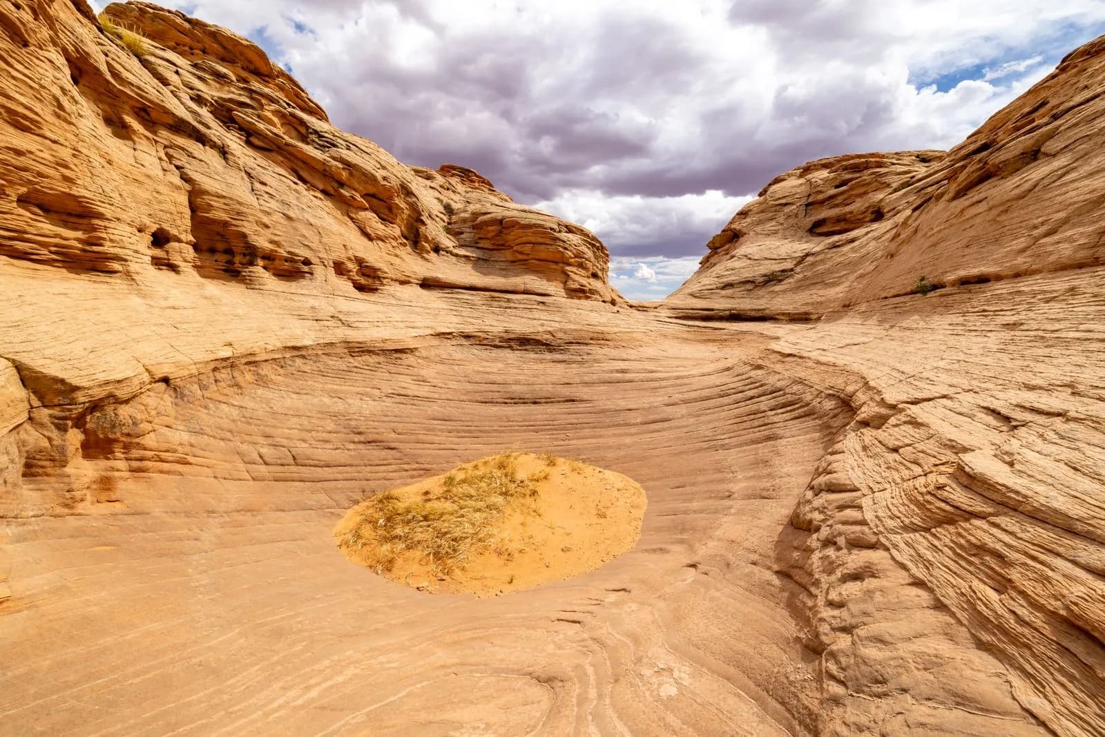 Scenic sandstone canyon landscape with eroded rock formations under a cloudy sky in a desert setting