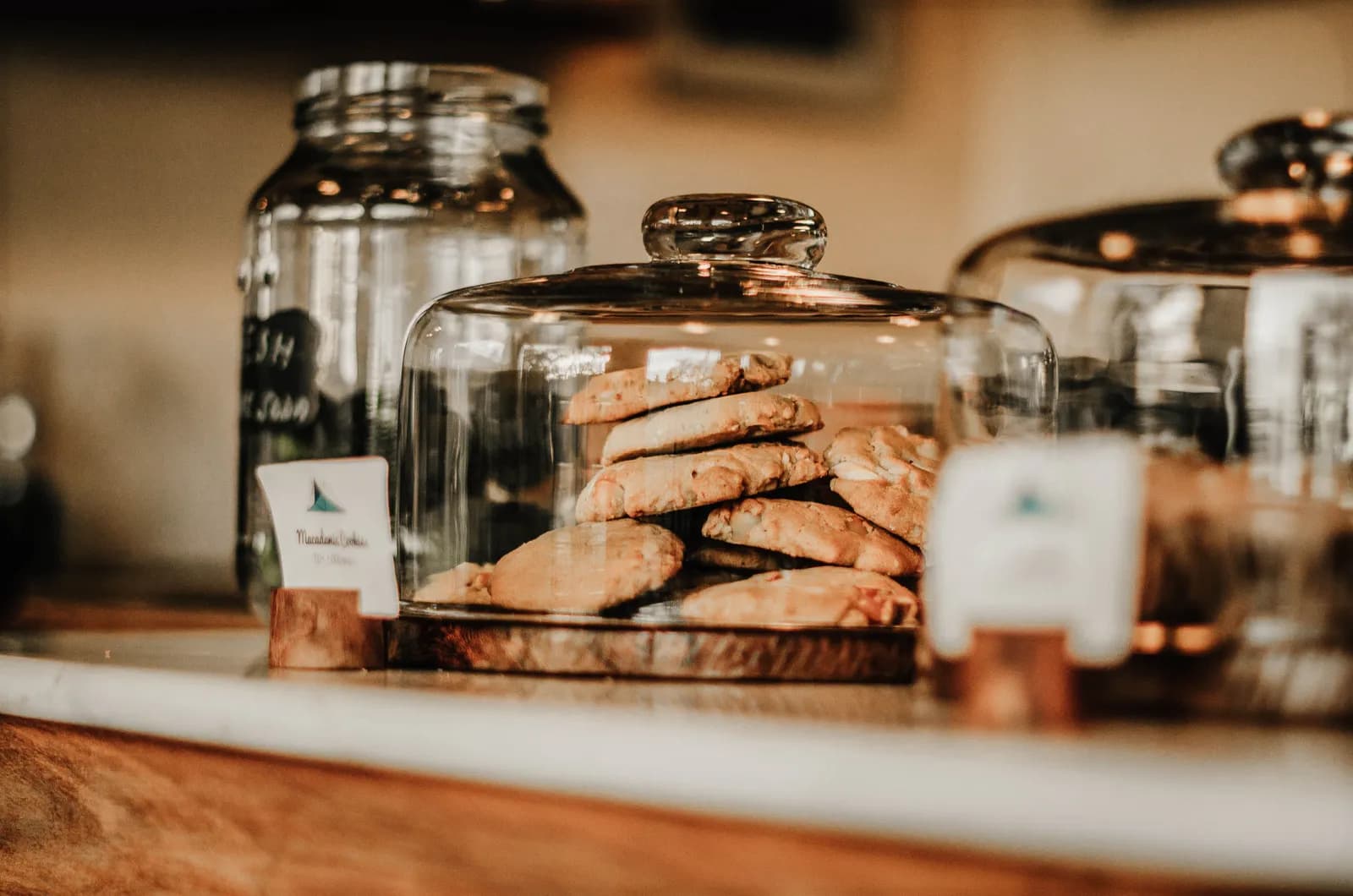 Homemade spiced cookies in glass jar on rustic wooden countertop for bakery display