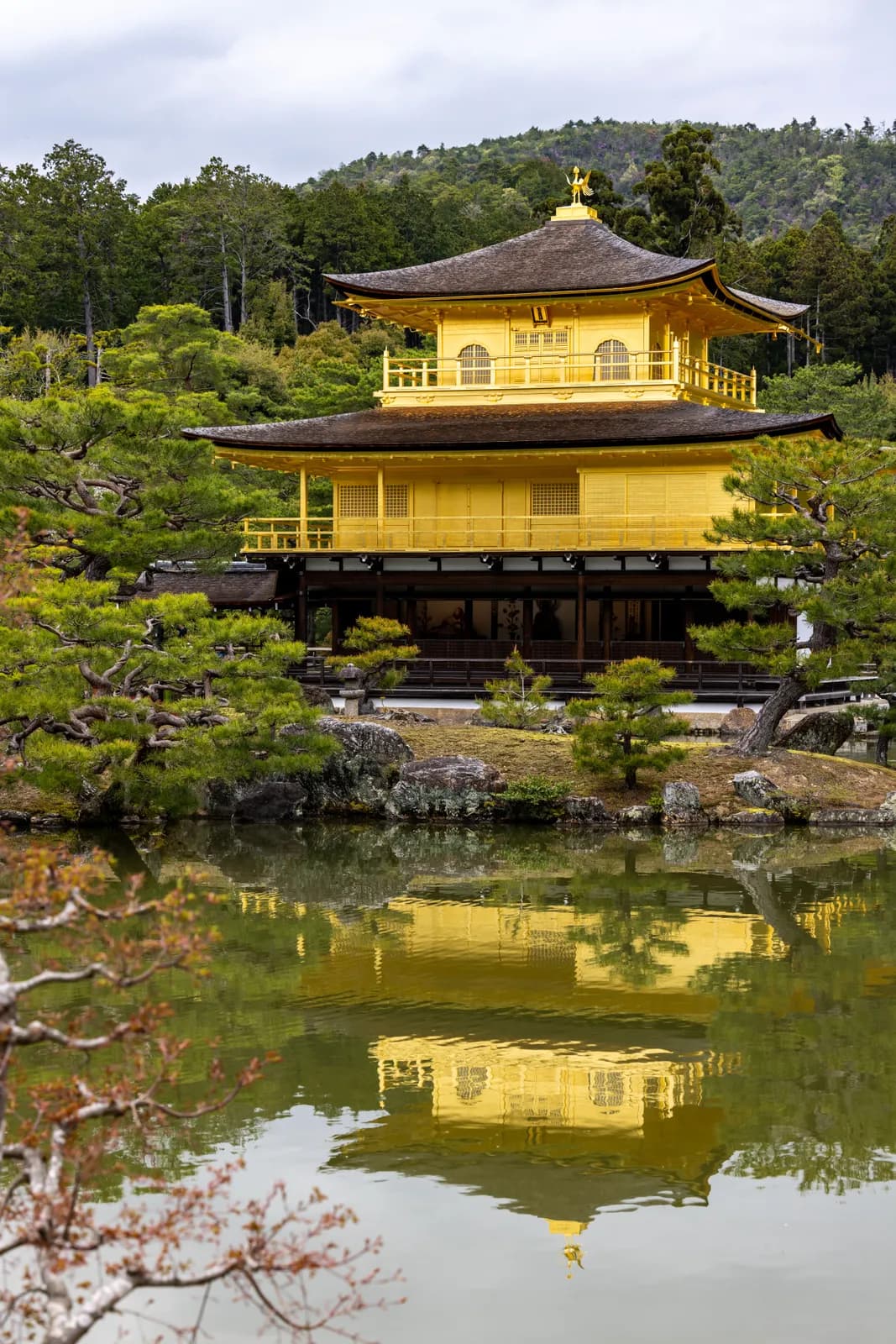 Kinkakuji golden pavilion temple reflecting in the pond in kyoto japan during a cloudy spring day