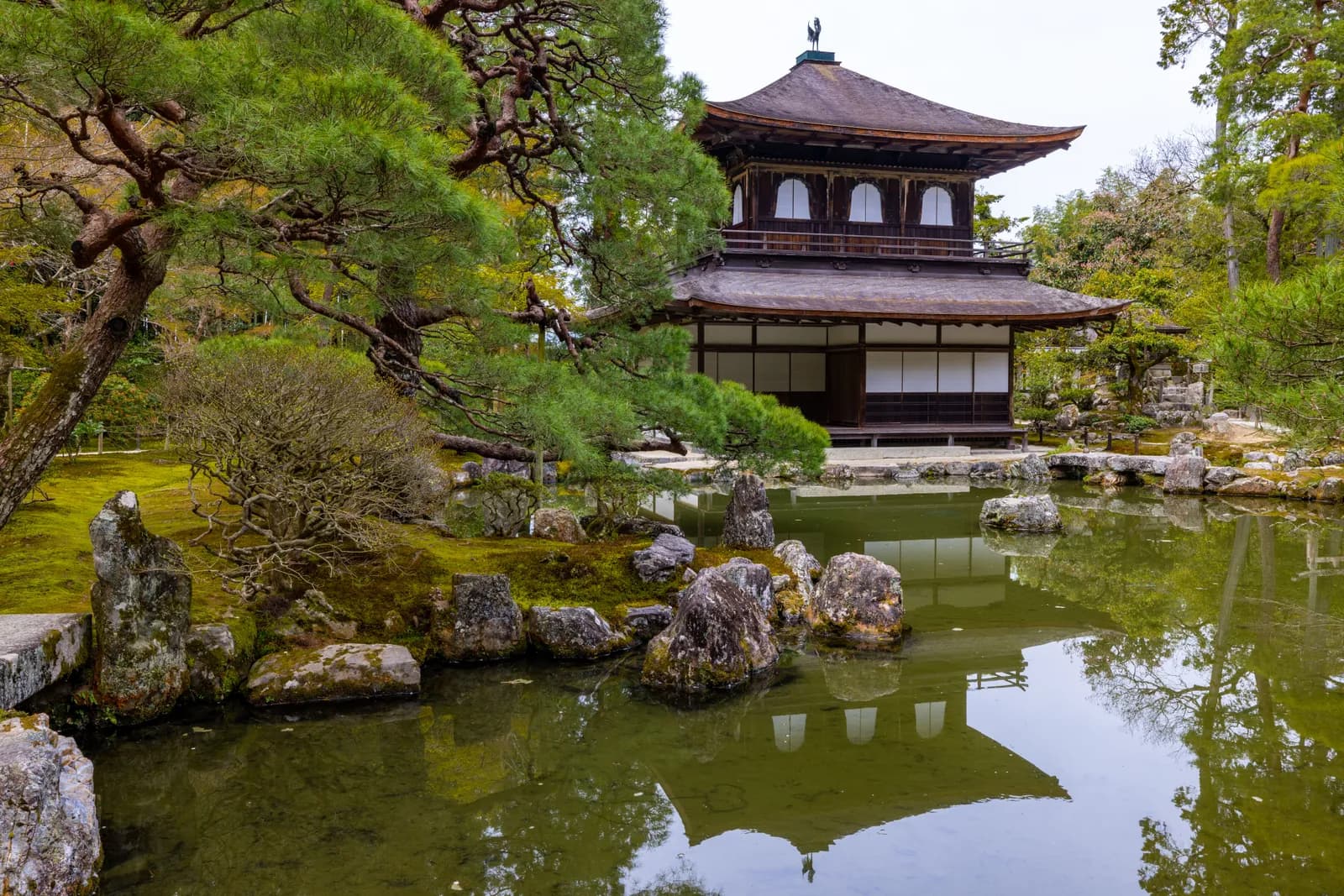 Traditional japanese temple architecture with zen garden and pond in kyoto during spring season