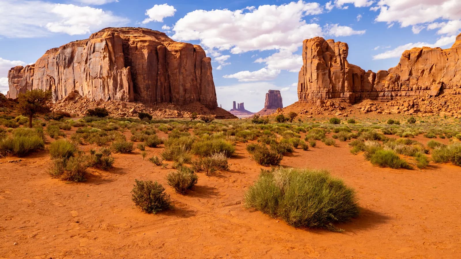 Scenic view of monument valley desert landscape with red sandstone buttes under blue sky