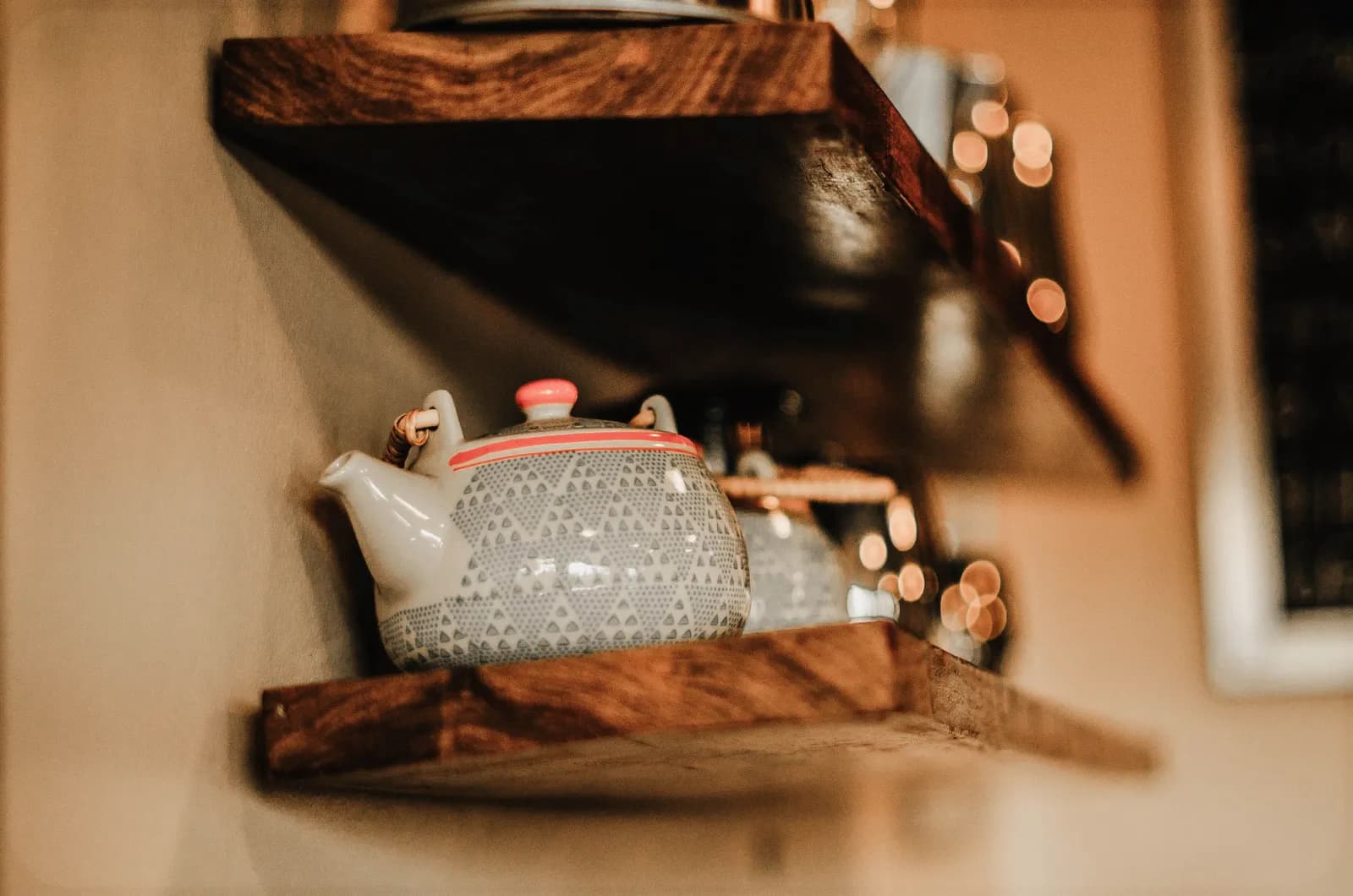 Vintage teapot with intricate design on rustic wooden shelf in cozy home setting