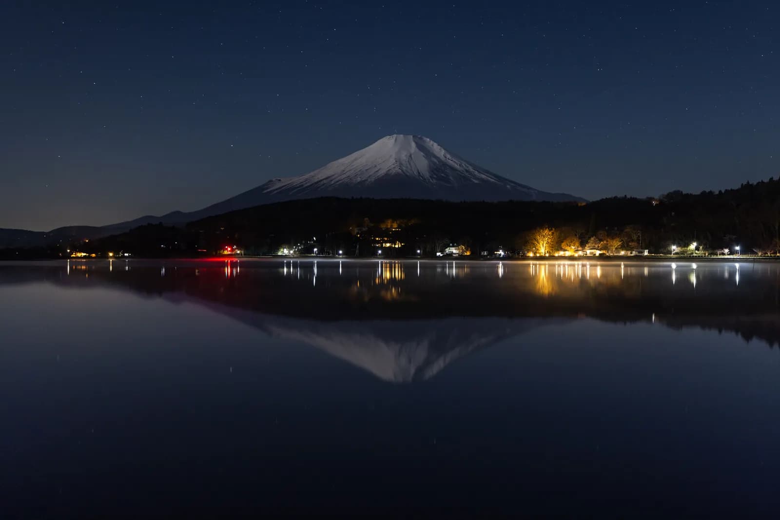 Mount fuji at night with reflection in lake kawaguchi under starry sky