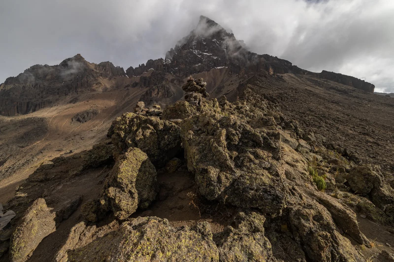 Volcanic eruption with steam plume rising from rocky mountain landscape