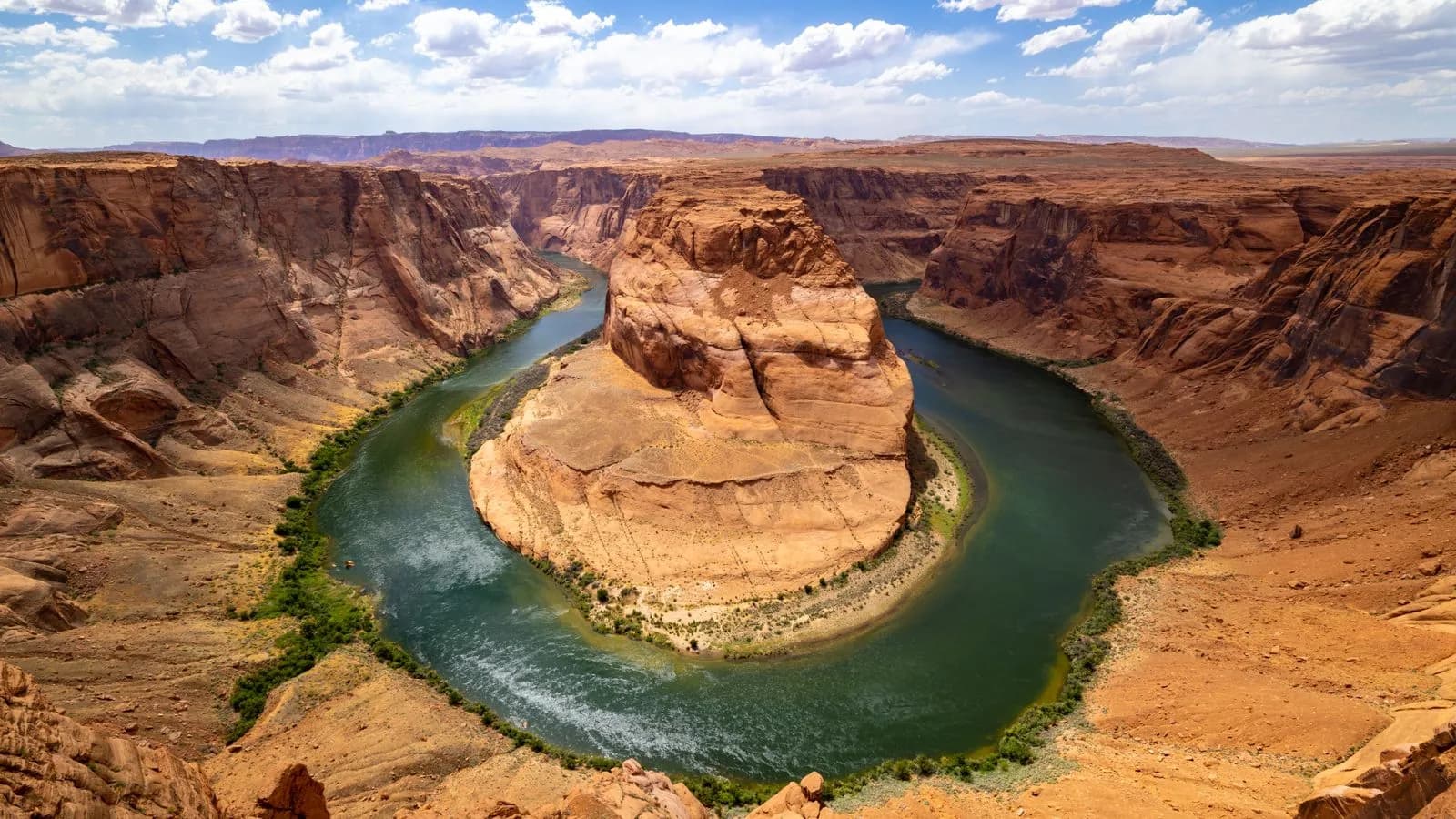 Horseshoe bend canyon with colorado river flowing through arizona desert landscape under blue sky