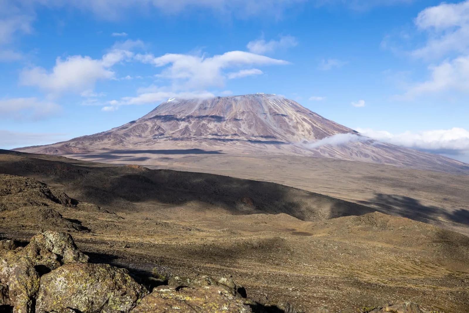 Majestic mount kilimanjaro volcanic landscape with rocky terrain and blue sky in tanzania africa