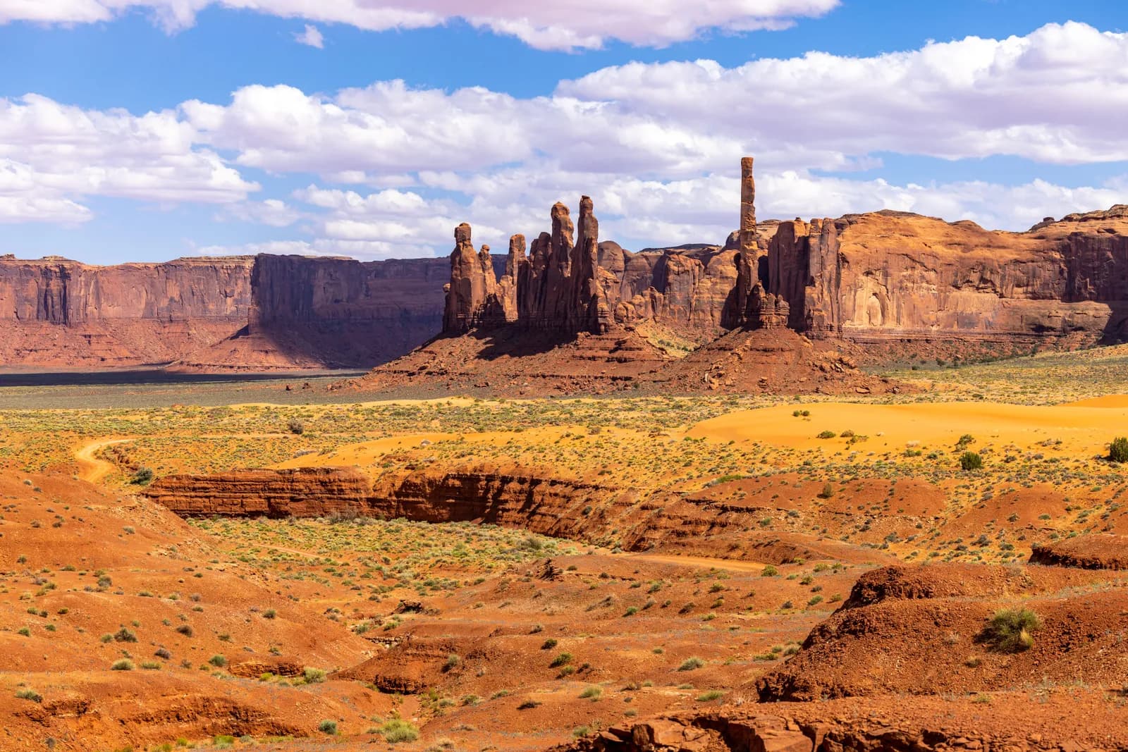 Scenic landscape of monument valley with sandstone buttes and desert terrain under blue sky
