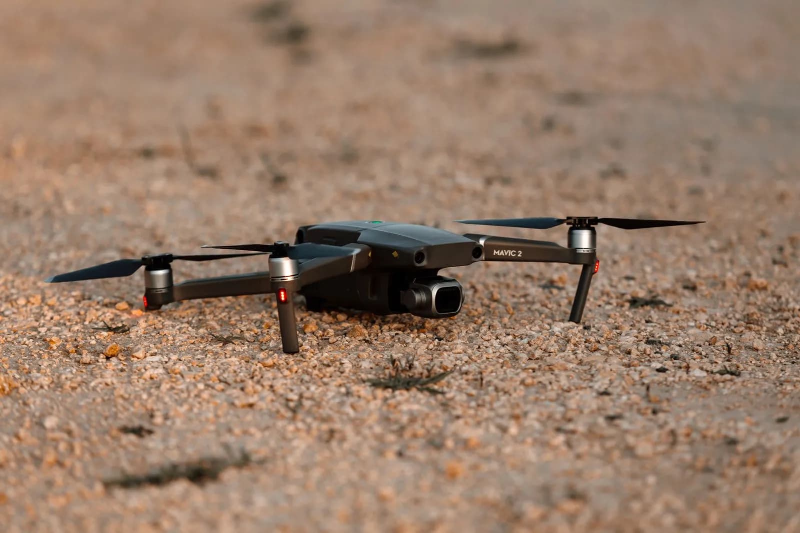 Modern quadcopter drone resting on a gravel ground surface for aerial photography and video production