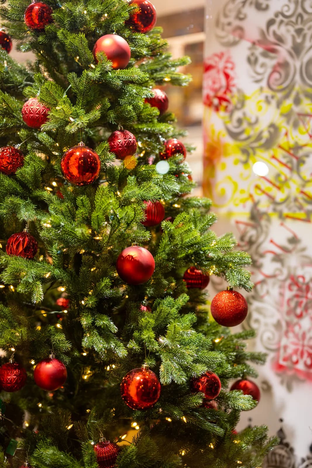 Decorated christmas tree with red ornaments and glowing fairy lights for holiday season celebration